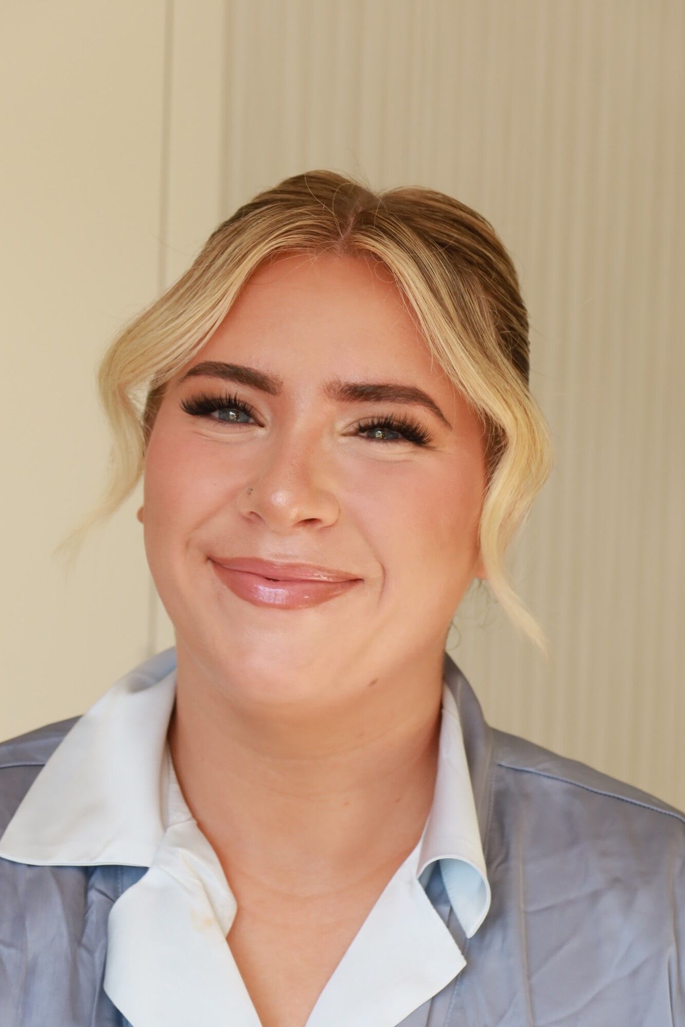 After: the same woman with a soft updo, face-framing pieces and finished makeup