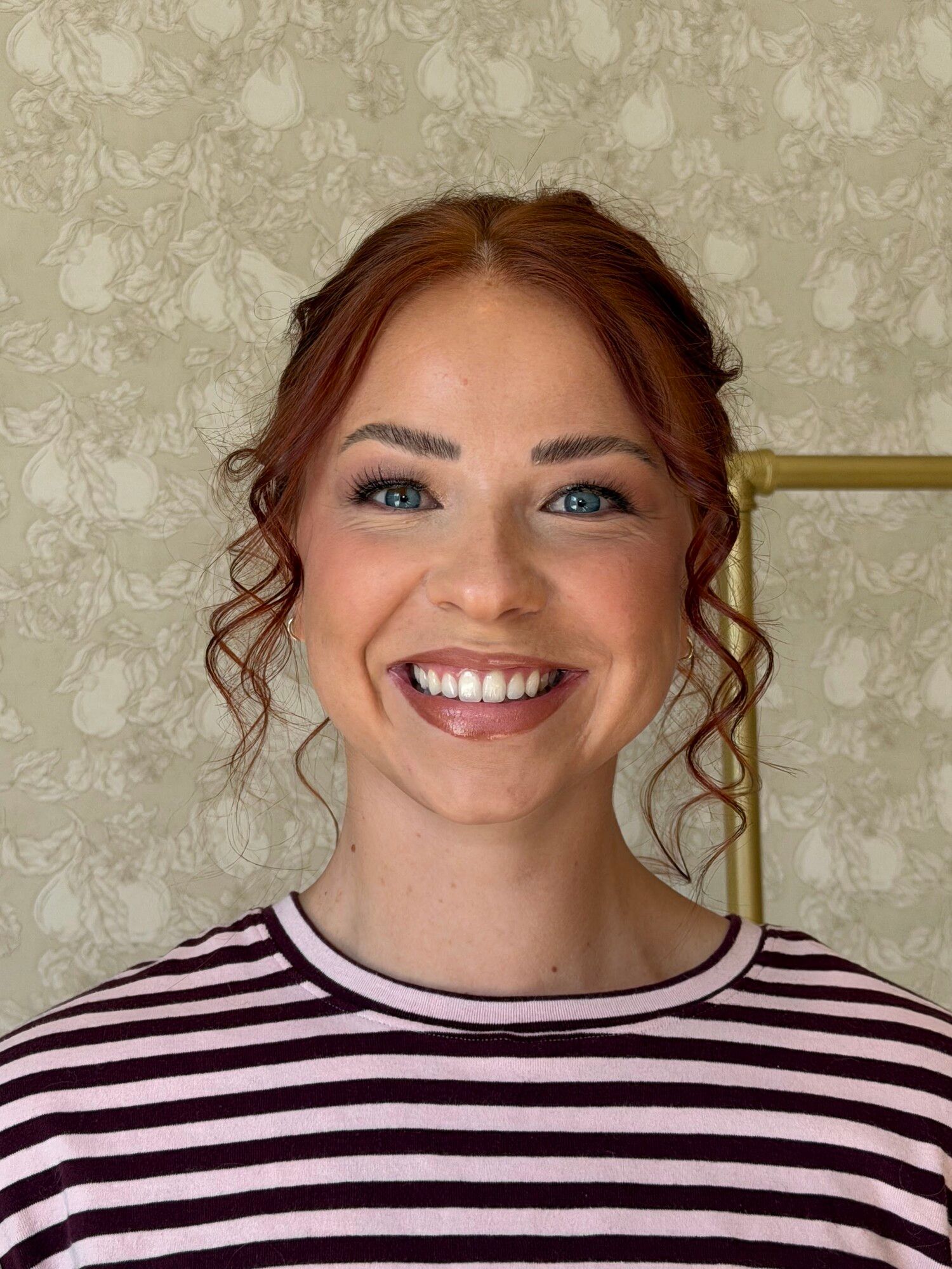 After: the same woman in soft glam makeup with loose curls framing her face