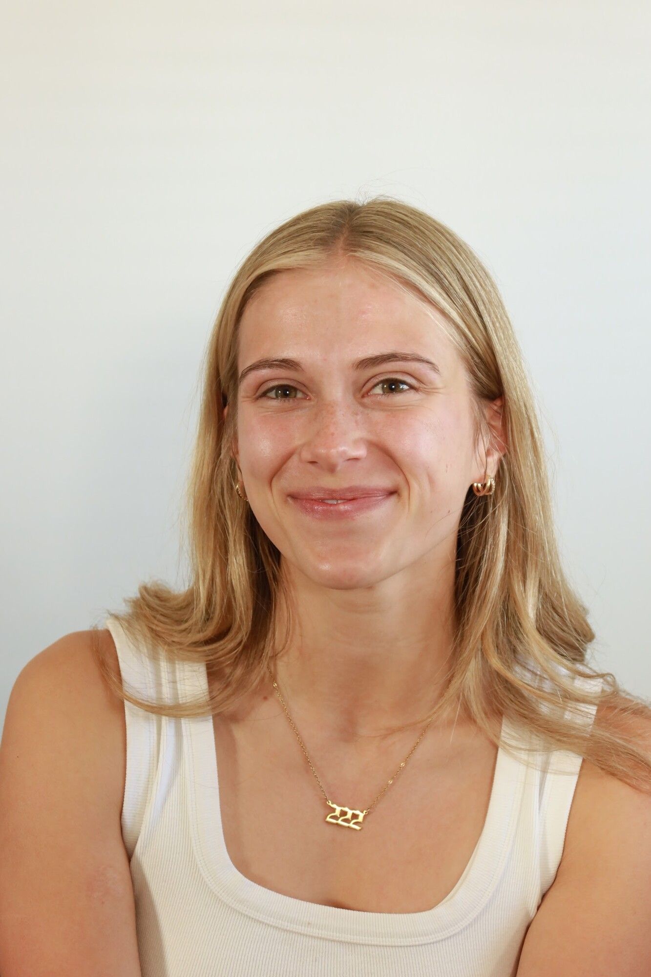 Before: a blonde woman in a white tank top with bare skin