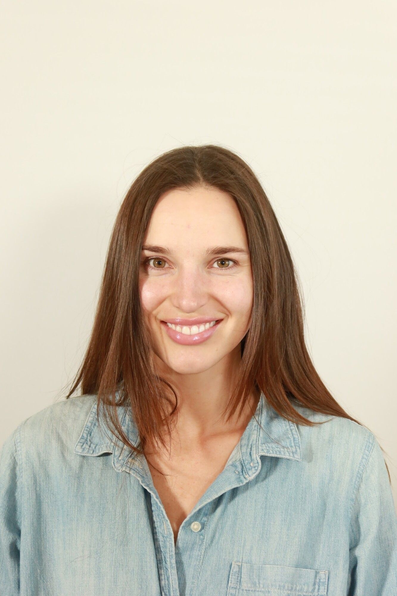 Before: a brunette woman in a denim shirt with straight hair and bare skin