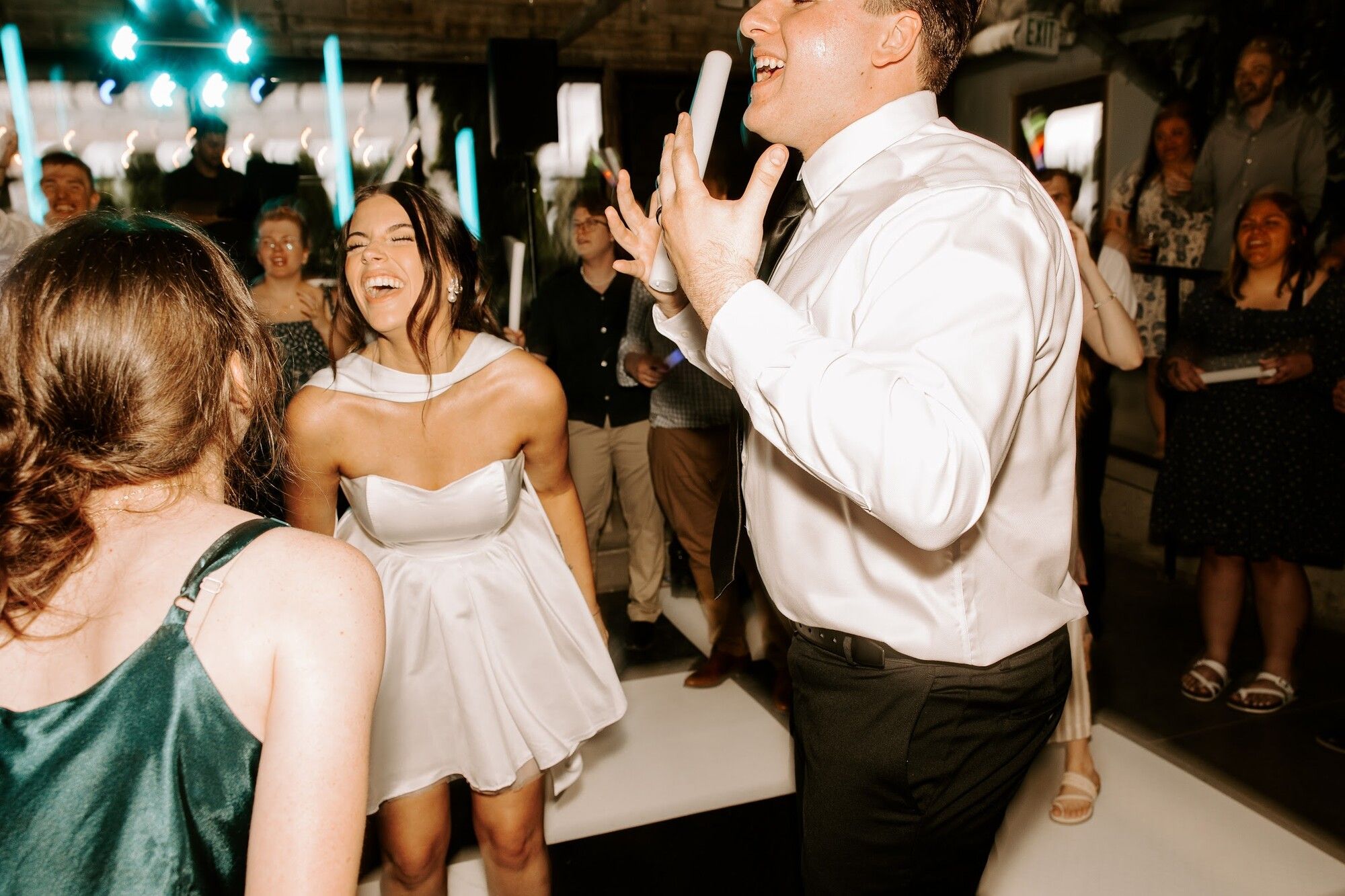 The bride and groom on a crowded dance floor at the reception